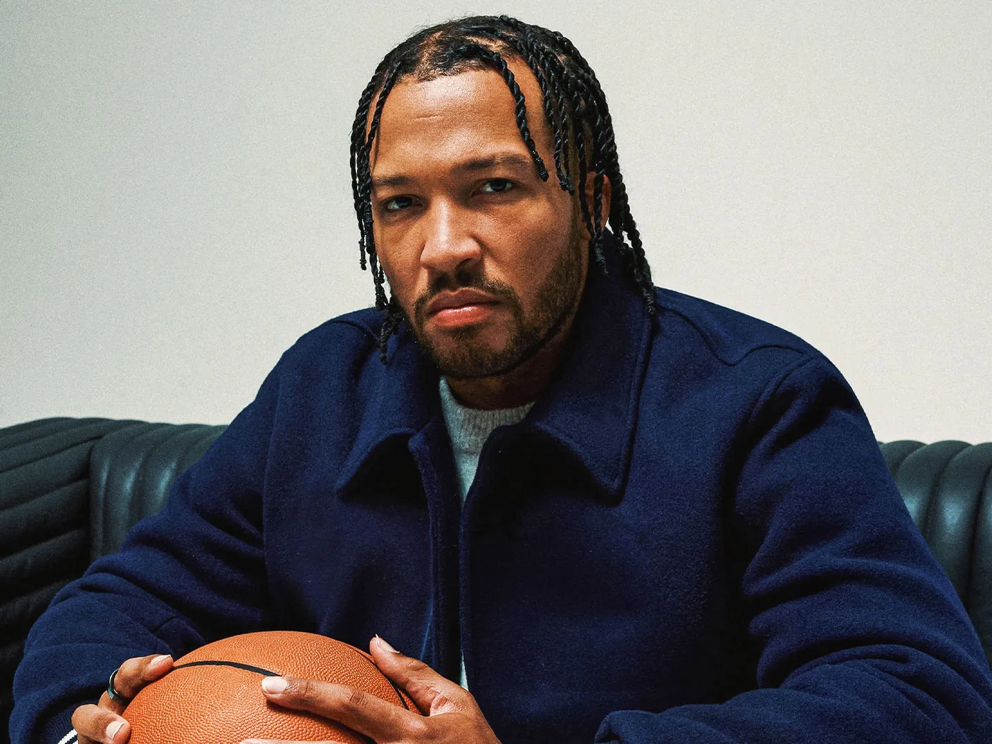 New York Knicks star Jalen Brunson seated and holding a basketball.